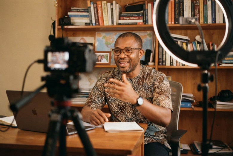 A teacher recording a lesson on camera at his desk
